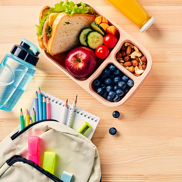 Nahrhafte Pausenmahlzeit auf dem Tisch neben Schulutensilien